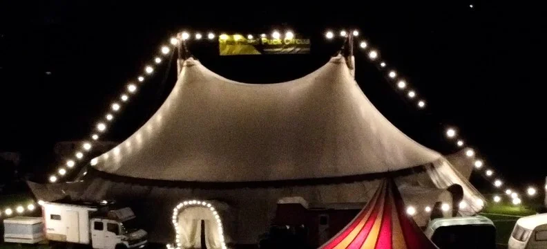 The white Revel Puck big top glowing at night